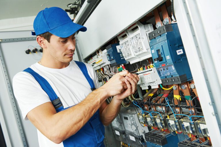 A man is fixing wires on electrical board to prevent accident